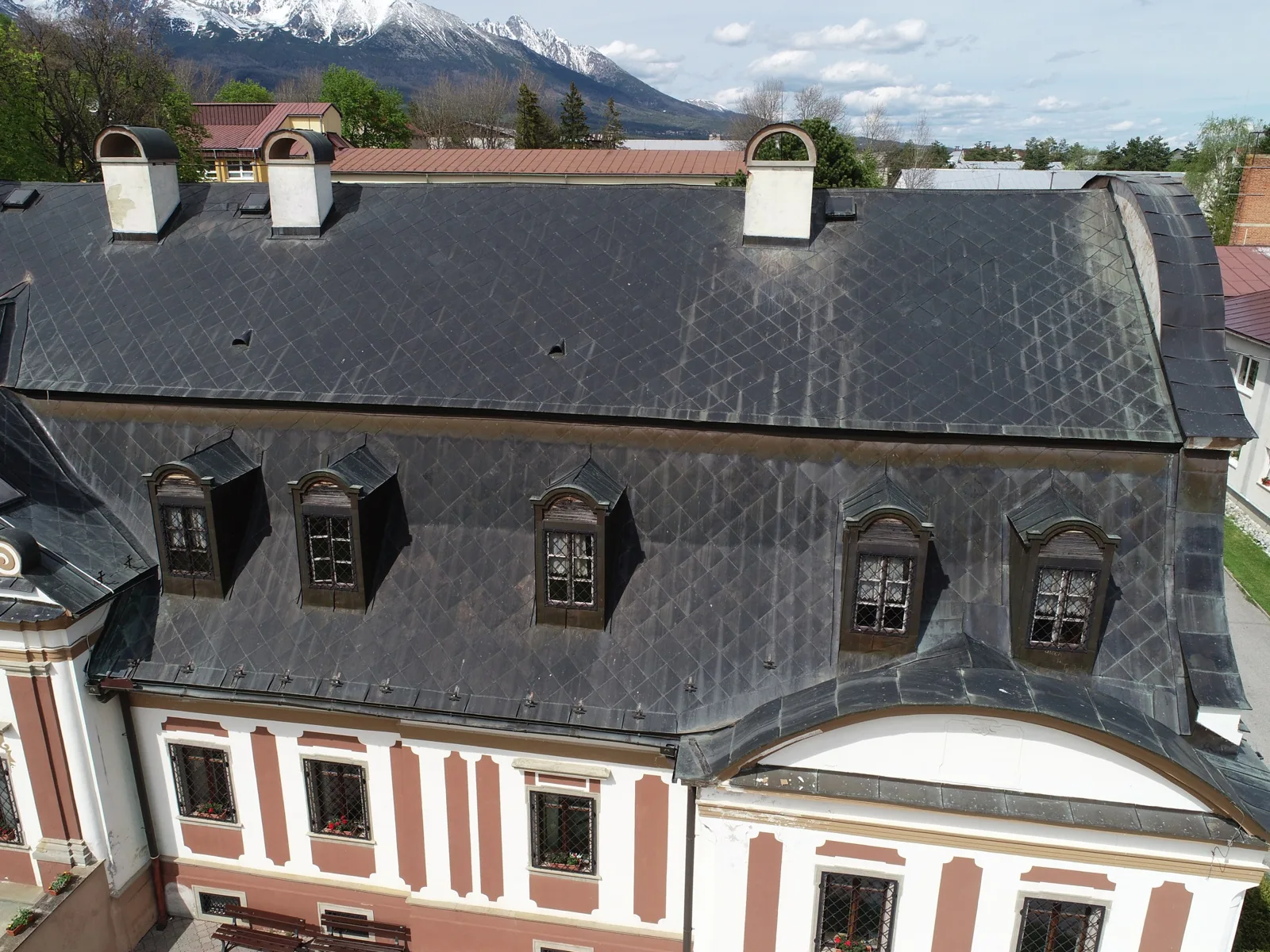 Strecha kaštieľa v Batizovciach z dronu, v pozadí Vysoké Tatry